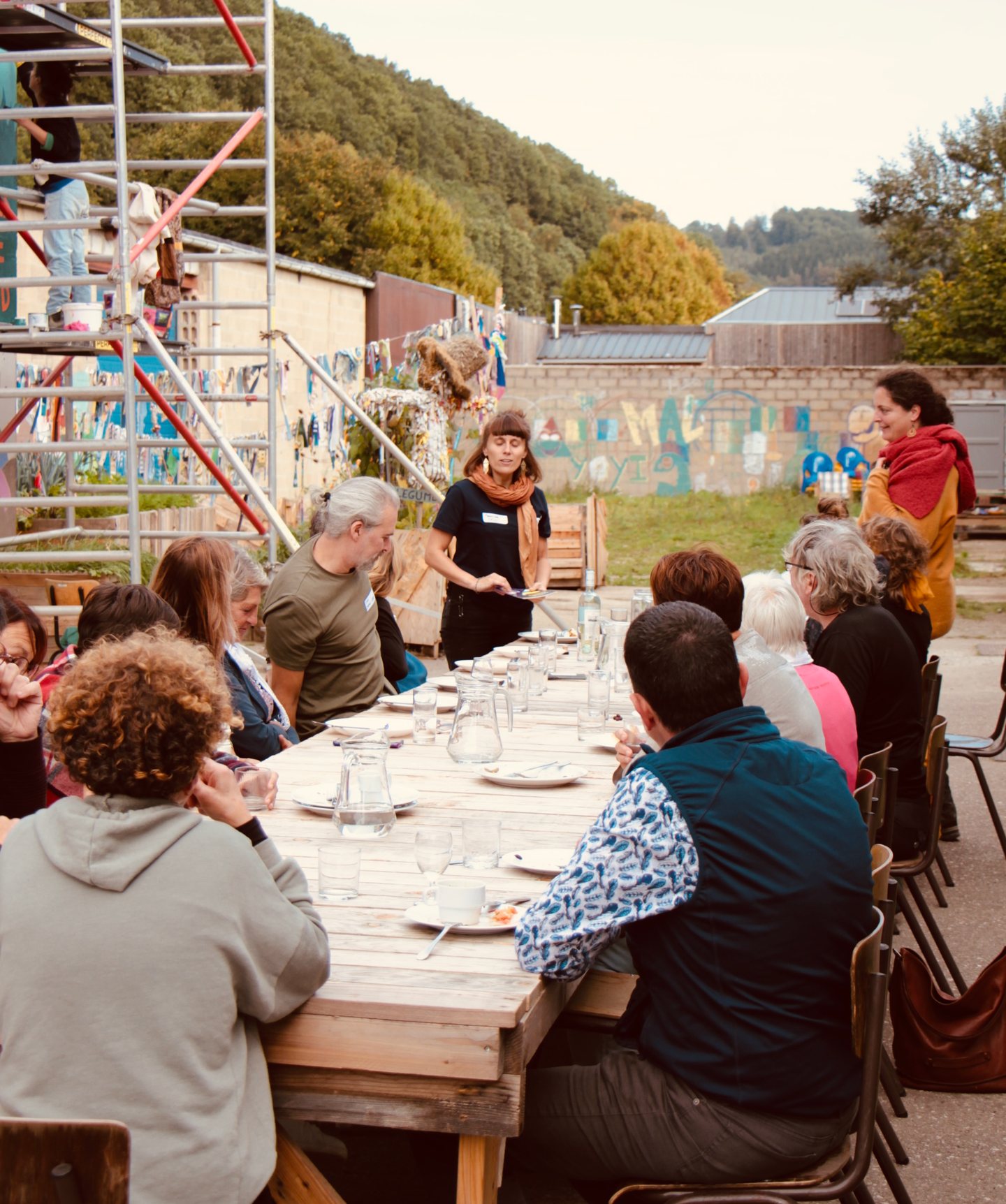 Repas partagé en plein air autour d’une grande tablée, lors d’une rencontre associative du territoire.